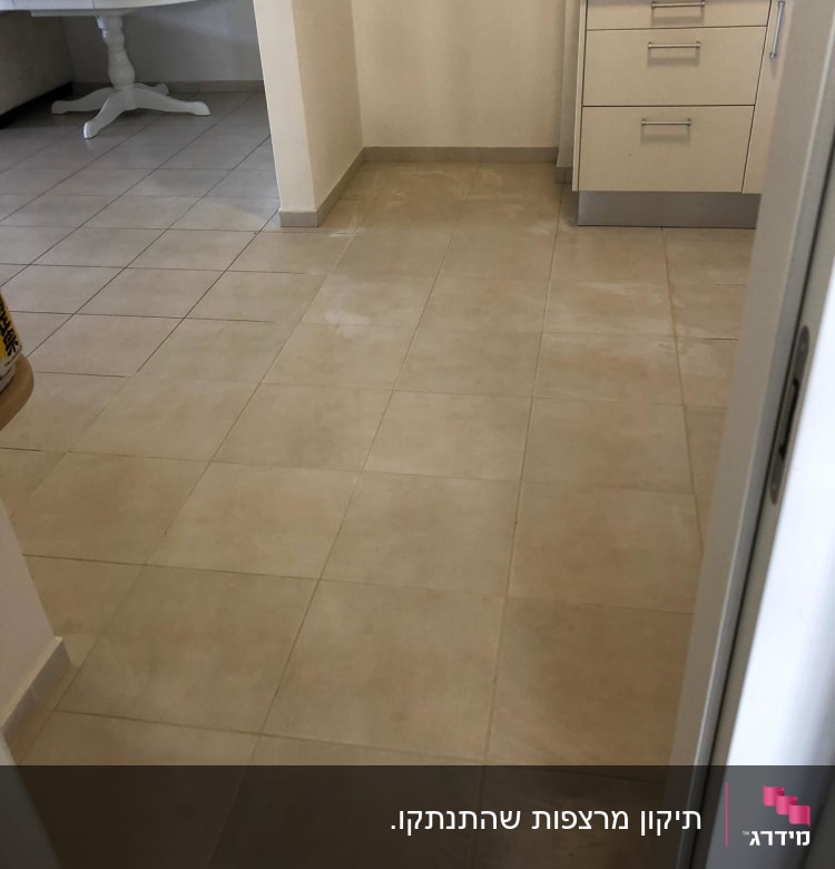 רצפת אריחים נקייה במטבח עם ארונות בהירים